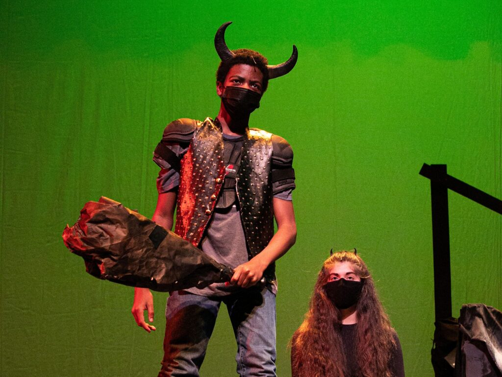 A masked performer with horns and a club in CTA's She Kills Monsters