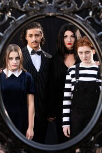 The Addams Family cast members pose in a family portrait frame
