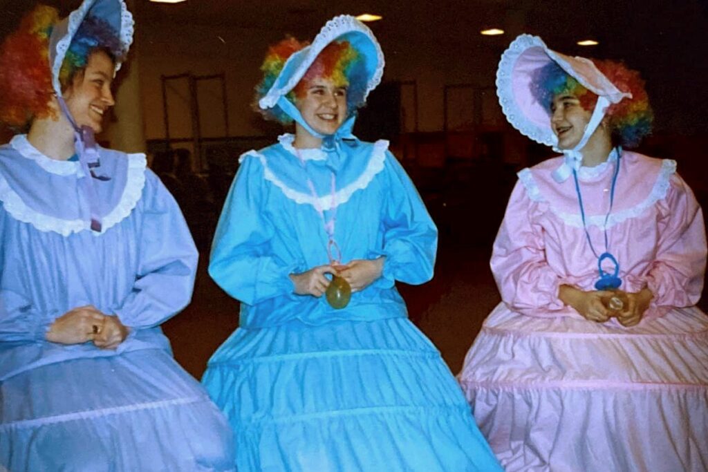 Three performers in pastel bonnets and dresses in CTA's 1991 The Wizard of Oz