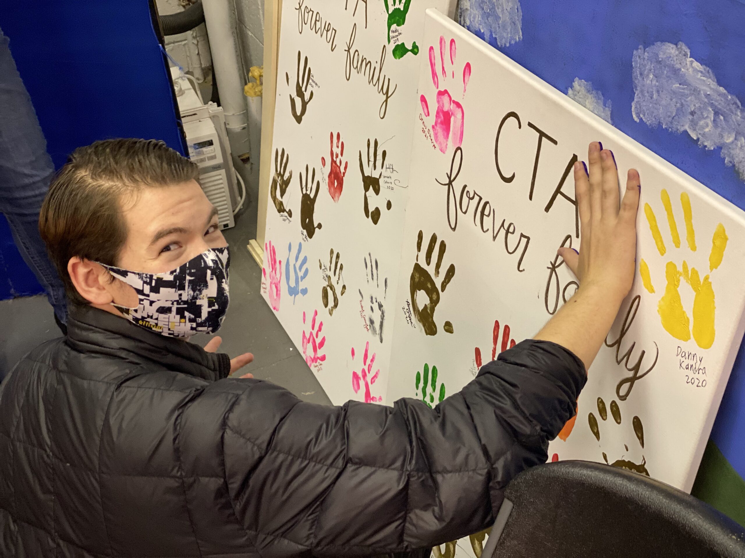 A CTA student decorating a hand-painted CTA banner
