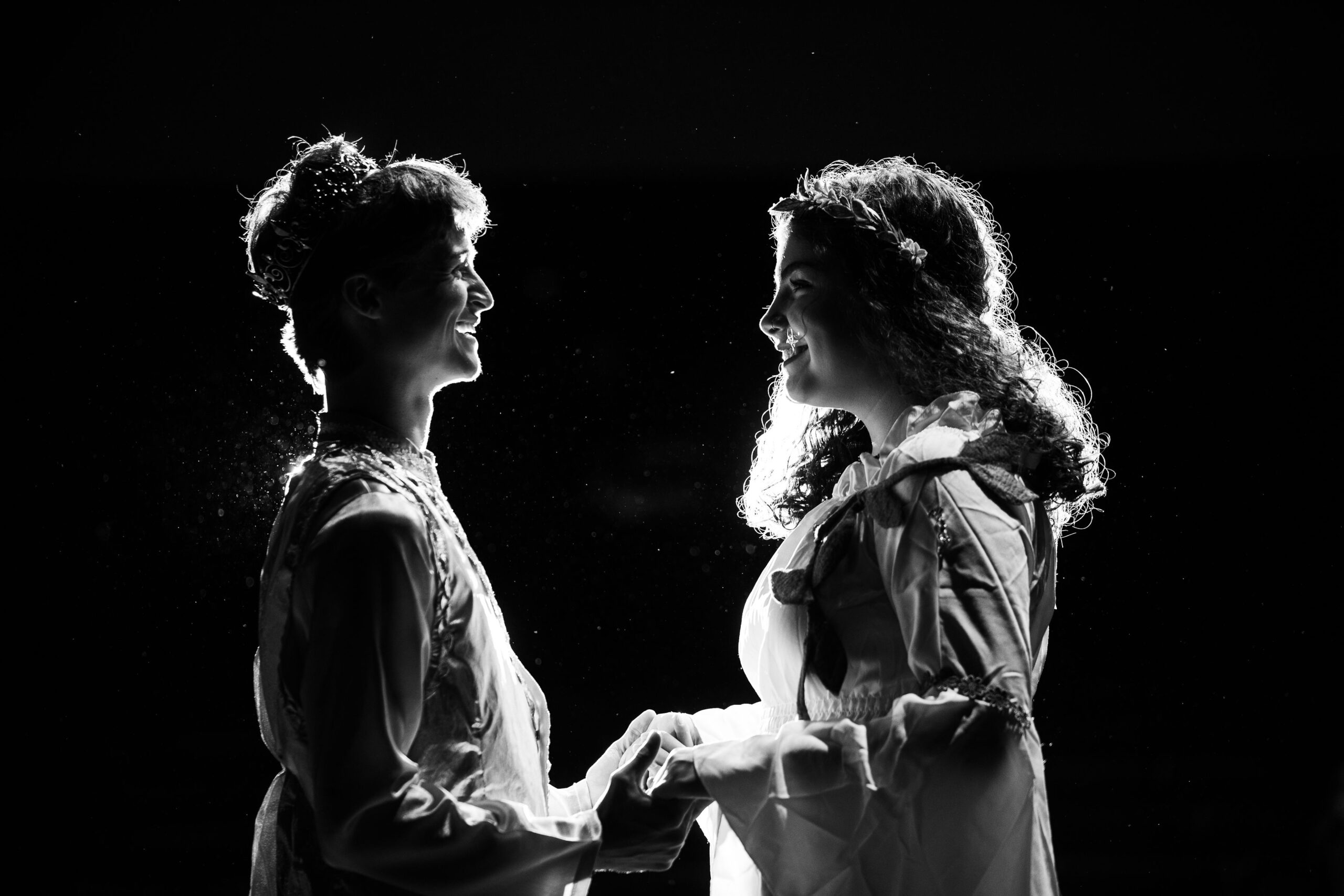 Two performers in silhouette face each other holding hands in CTA's Once Upon a Mattress